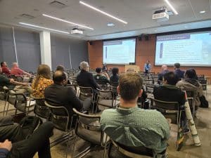 Students and faculty in a conference room at a panel session